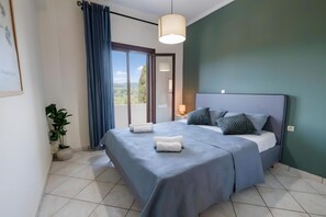 A bedroom with a bed, a potted plant, a view through a window, and a hanging light fixture. - Apartment 'Breathing  2' with Mountain View, Wi-Fi and Air Conditioning (Virós)