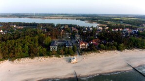 Ett flygbildsbild av ett kustområde med en strand, ett stort byggnadskomplex och en flod i bakgrunden.