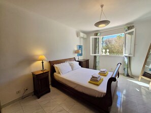 A bedroom with a bed, bedside tables, a lamp, a window with curtains, and a view of greenery outside. - Villa Joseli /Private pool/6 guests (Oletta)