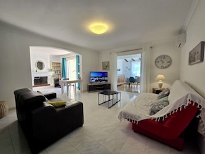 A living room with a sofa, TV, and a dining area with a table and chairs. - Villa Joseli /Private pool/6 guests (Oletta)