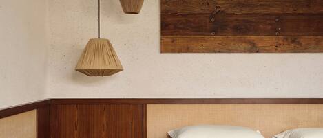 A hotel room with a bed, bedside table, and a wooden headboard.