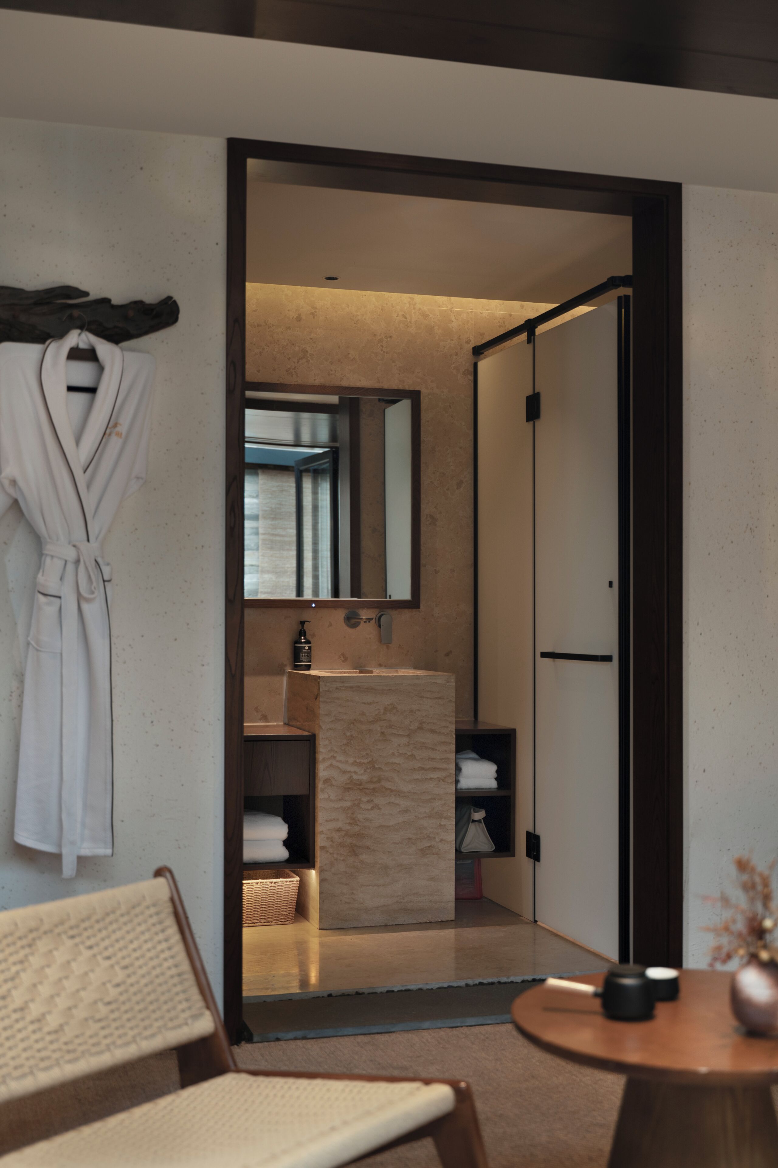 Un baño moderno con un espejo grande, un perchero para toallas y una zona de ducha.