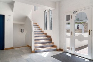 A staircase with a white door and a blue door, a tiled floor, and a wall-mounted light fixture. - Cargol De Mar, sea views and pool (L'Escala)