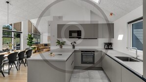 Una cucina moderna con forno a microonde integrato, macchina del caffè e lavello.