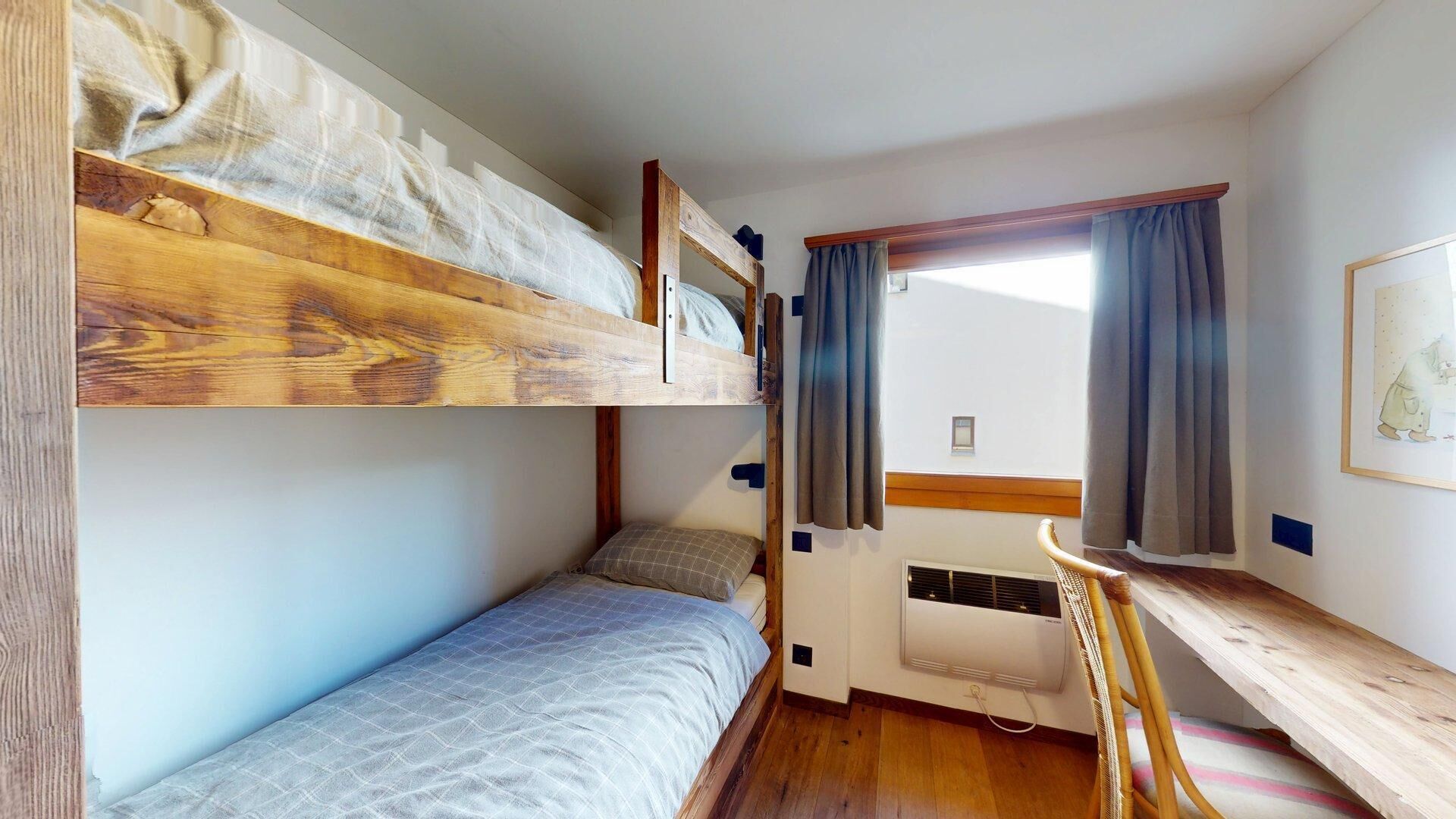 Habitación con literas, un escritorio y una ventana.