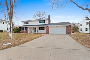 A two-story house with a garage, a front porch, and a driveway.