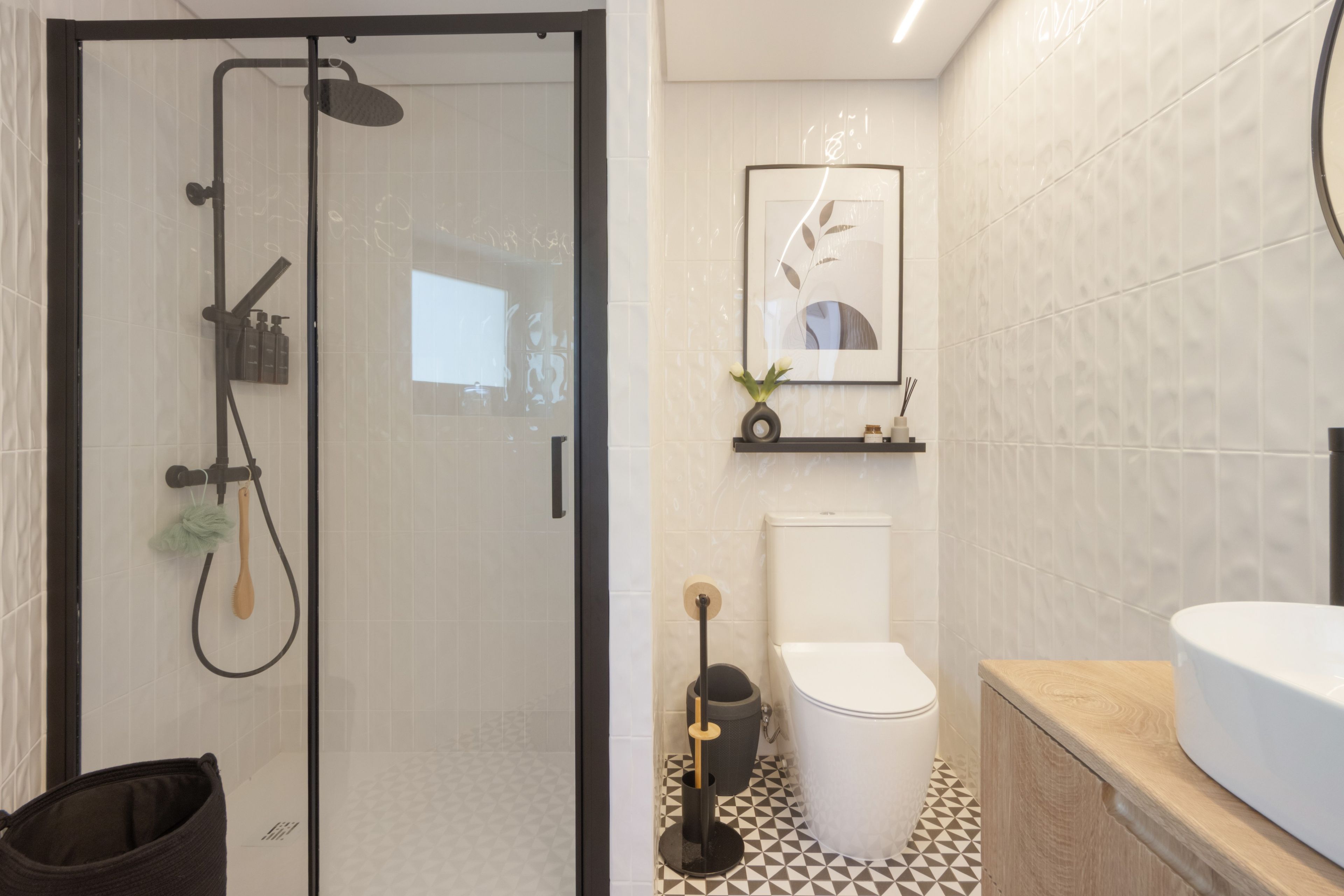 Une salle de bain moderne avec une douche à parois de verre, des toilettes et un espace lavabo.