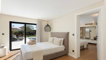 A bedroom with a bed, a large window, and a view of a swimming pool.