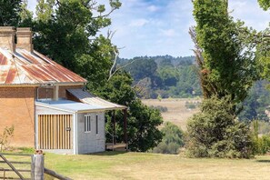 A rustic house with a metal roof, a wooden door, and a covered porch.