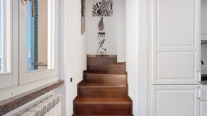 Una escalera de madera con un radiador a la izquierda y un armario blanco a la derecha.