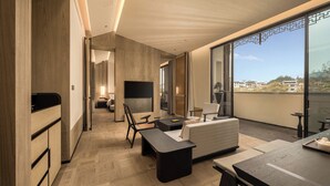 A modern hotel room with a balcony, a sofa, a dining table, and a TV. - Steigenberger Icons Guizhou Xiaoqikong (Qiannan)