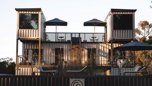 A modern building with multiple levels, outdoor seating, and a staircase.