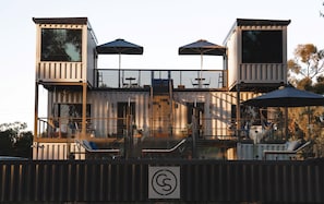 A modern building with multiple levels, outdoor seating, and a staircase.