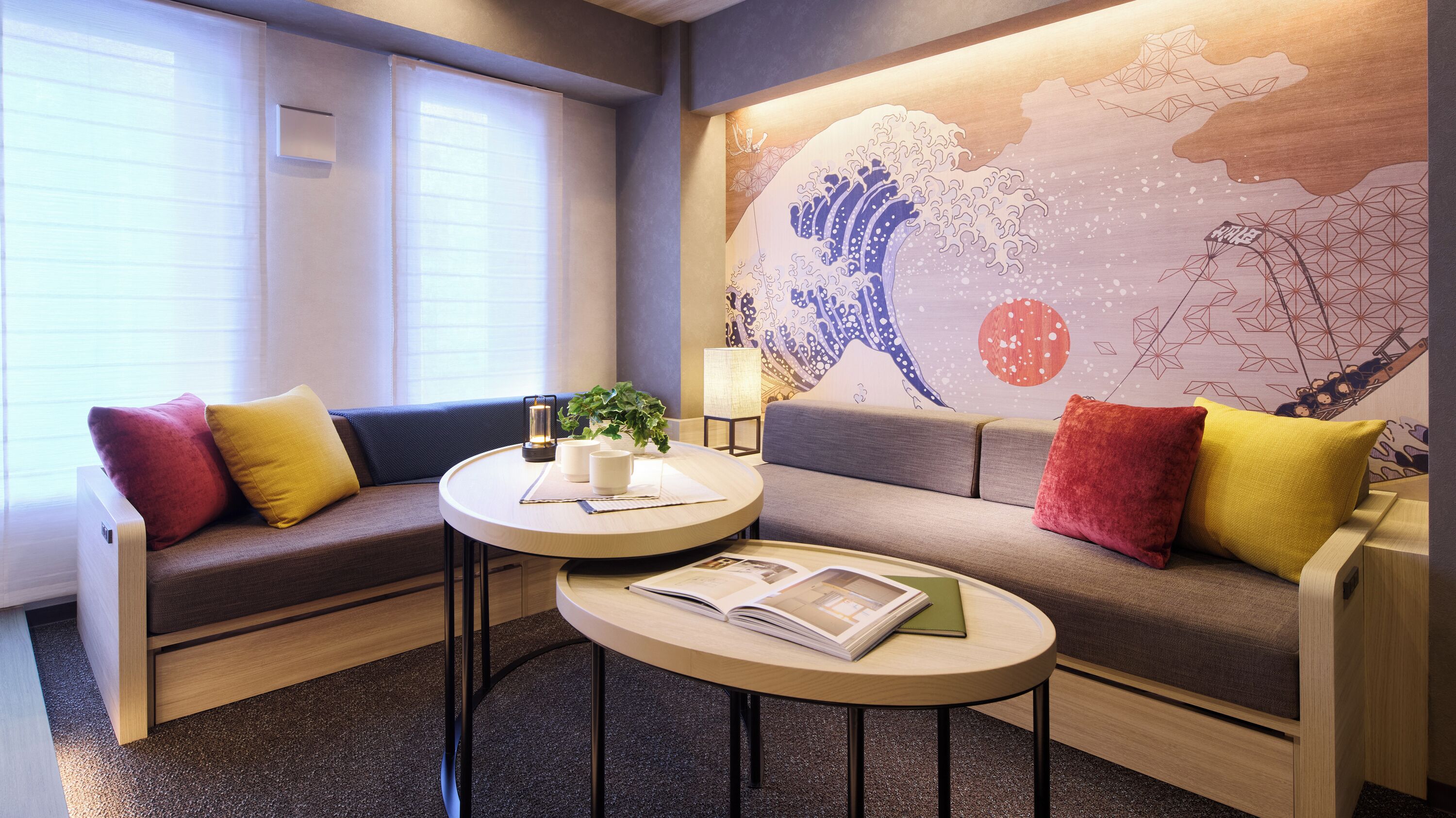 A modern room with a sofa, a small round table, and a wall mural.