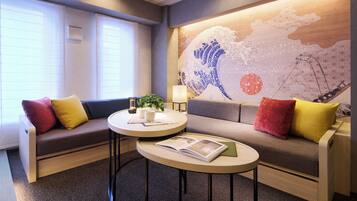 A modern room with a sofa, a small round table, and a wall mural.