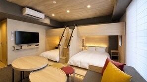 A hotel room with a TV, two beds, a staircase, a round table, and a small stool.