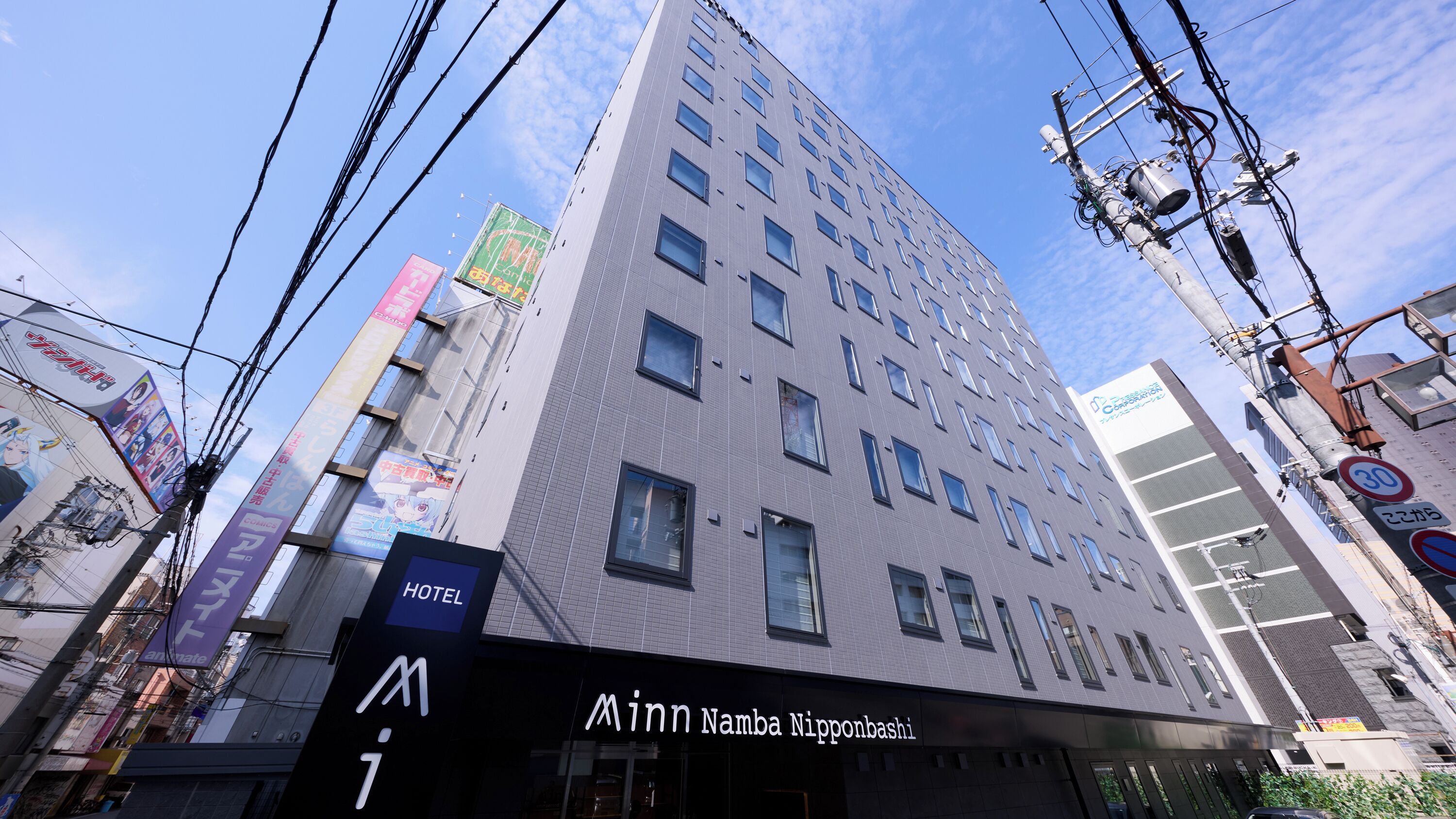 A multi-story building with a sign for 'M Inn Namba Nipponbashi.'