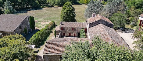 A rural village with stone buildings, a church, and surrounding greenery.