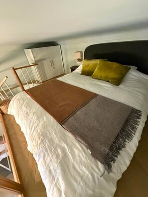 A bed with a white comforter, a brown throw blanket, and a gray blanket with fringe. - Mediterranean Dream - Carré d'Or (Nice)