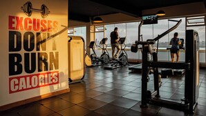 A gym with exercise equipment, a motivational poster, and large windows offering a view. - Modern 2 Bedroom Westlands Nairobi,  with AC, Rooftop Pool, Gym, Squash Court (Nairobi)