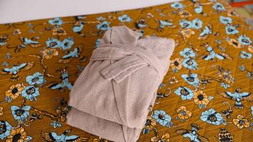 Una toalla sobre una cama con una colcha de estampado floral.