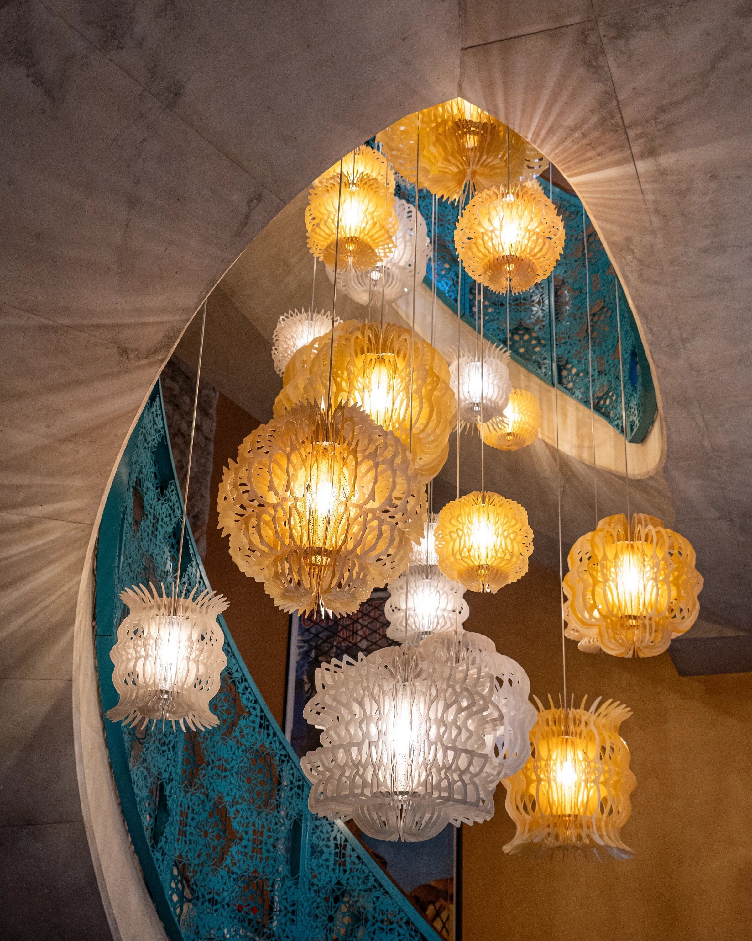 A spiral staircase with hanging paper lanterns.