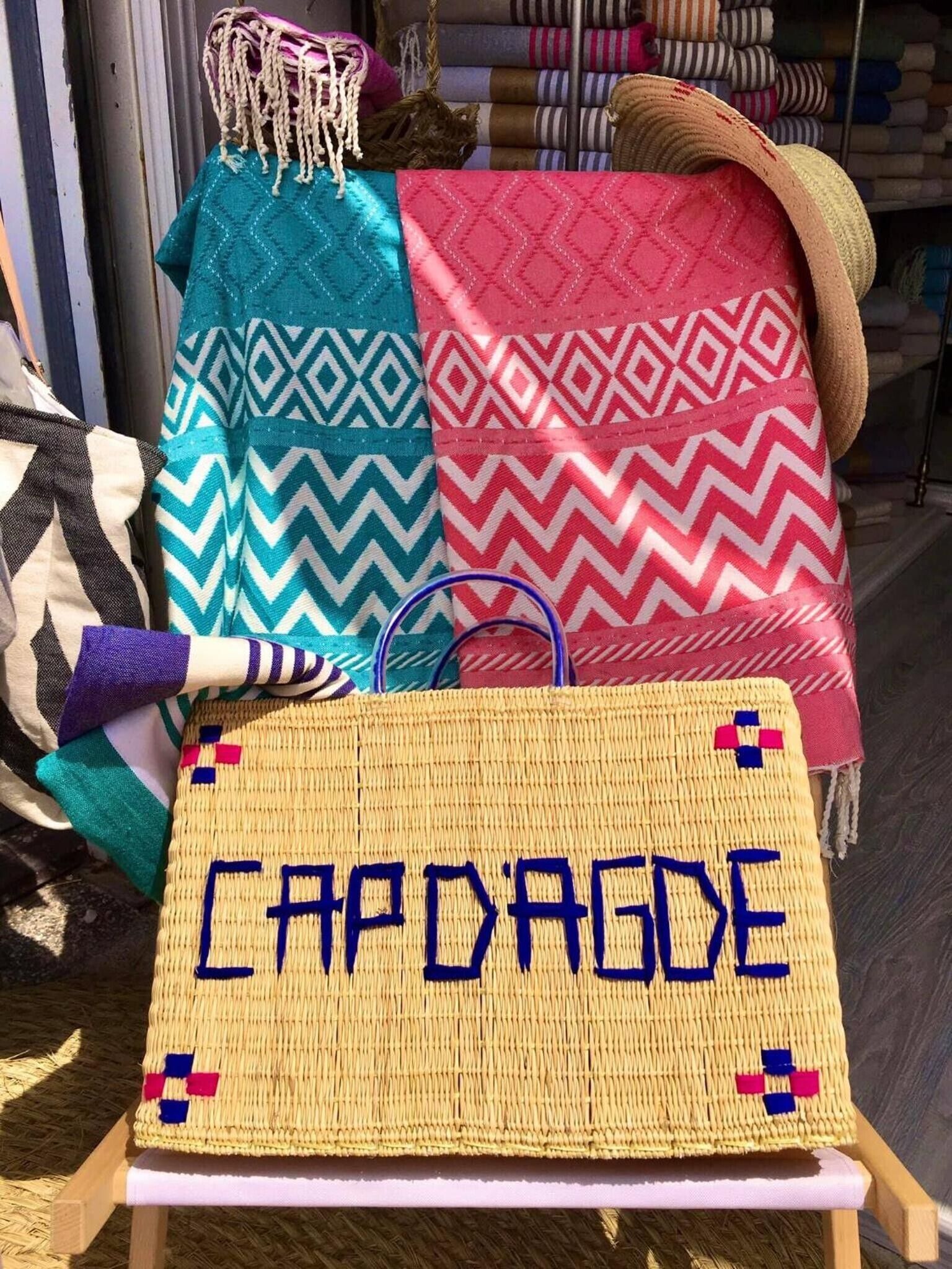 A display of woven textiles with geometric patterns and a woven placard with the word 'CAPODAGGE'.