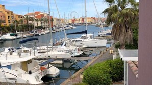 A marina with boats docked, a white fence, and a lounge chair. - Apartment 'Marina Oportoducap' with Lake View, Private Terrace and Air Conditioning (Agde)