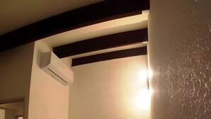 A bedroom with a bed, a nightstand, an air conditioning unit, and a door leading to another room. - Apartment 'Marina Oportoducap' with Lake View, Private Terrace and Air Conditioning (Agde)