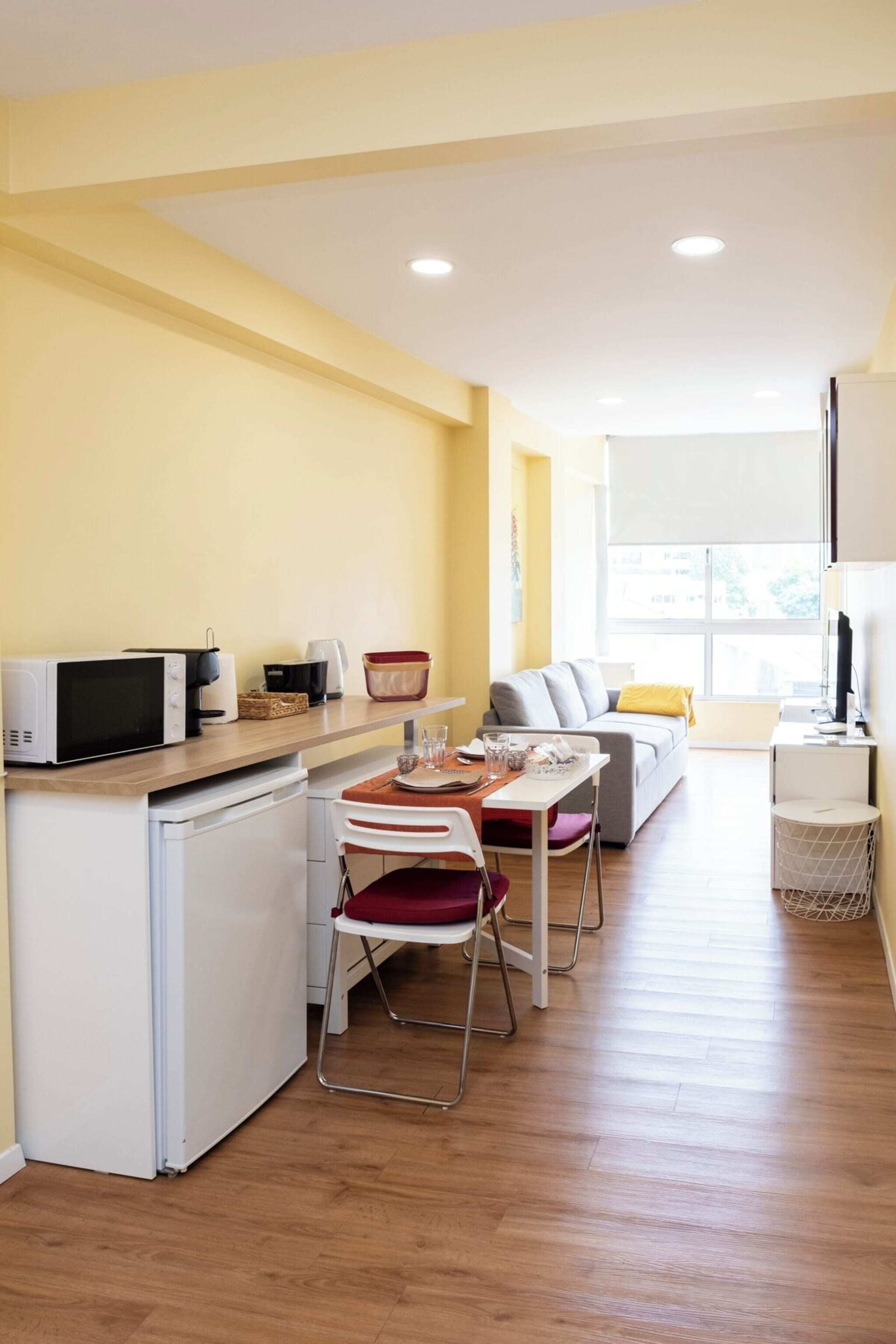 A compact living space with a kitchenette, dining area, and seating area.