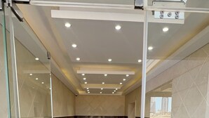 Una hall d'albergo con una reception, un bancone in vetro e un pavimento decorato.