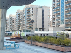 A modern apartment building with multiple balconies, a covered outdoor area with benches, and a sign for 'Downtown by CityEdge.'
