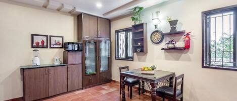 A kitchen with a dining table, cabinets, and a ceiling fan.