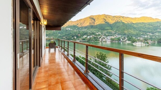 A balcony with a view of a lake and mountains. - ELIVAAS Lakeview Manor 3-BHK Luxurious (Bhimtal)