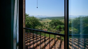 A balcony with a view of a green landscape and distant mountains. - Apartment '2' with Shared Pool and Garden, Wi-Fi, and Air Conditioning (Massa Marittima)