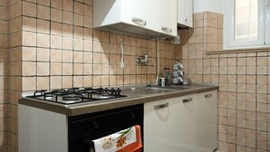 Eine Küche mit Gasherd, Backofen und weißen Schränken.