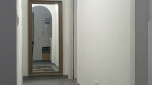 Ein Flur mit Teppichmuster, einer Tür und einer Wandleuchte.