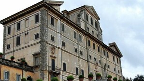 Ein historisches Gebäude mit mehreren Stockwerken, einer steinernen Fassade und einer Reihe von Fenstern.