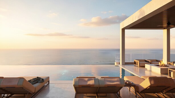 En modern infinitypool med utsikt över havet, solstolar och en bar.