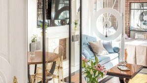 A modern interior with a dining area, a sofa, and a decorative circular element. - The Eleven by Fragola Apartments (Kraków)