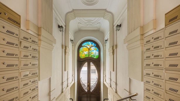 A grand staircase leading to a room with a large stained glass window. - The Eleven by Fragola Apartments (Kraków)