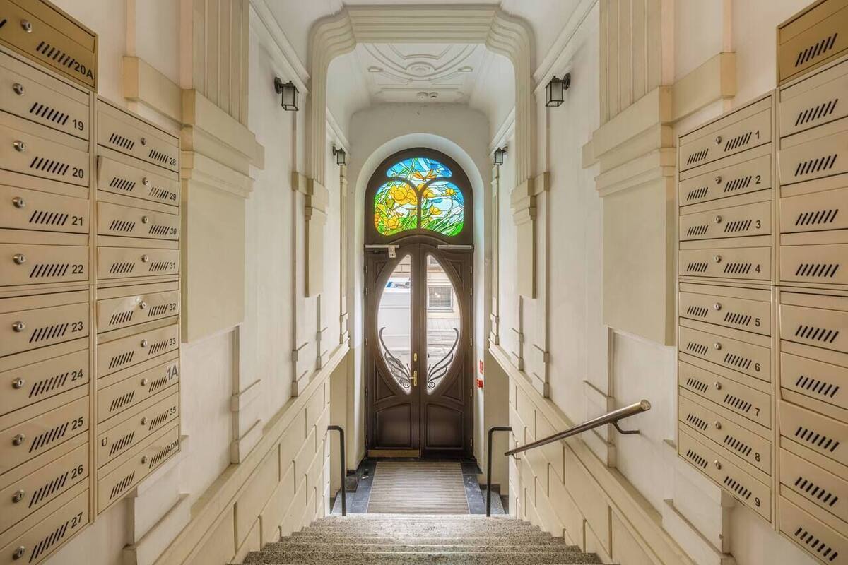 Eine prachtvolle Halle mit einem zentralen Buntglasfenster, gesäumt von Reihen nummerierter Schließfächer.