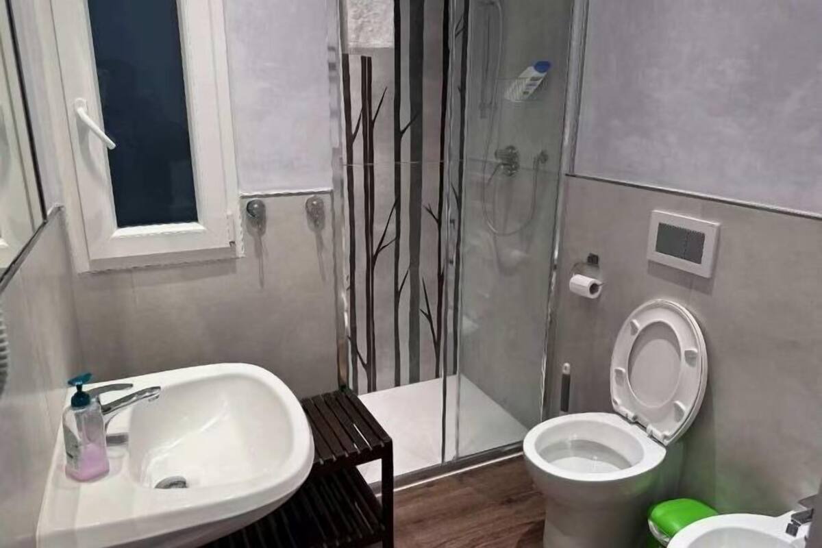 A bathroom with a sink, toilet, and shower.