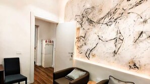 A modern interior with two leather sofas, a wooden floor, and a large abstract wall art piece.