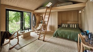 Ein Schlafzimmer mit Schlafbox, einer Leiter, einem Schreibtisch und einem großen Fenster.