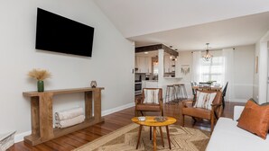 A modern living room with a sofa, chairs, a coffee table, a TV, and a fireplace. - Pool + Fenced Yard | 4BR Family Home | Close to 96 (Warner Robins)