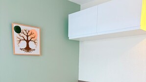 A bed with a white quilt, a headboard with a wooden panel, a green wall, and a framed picture of a tree. - St Cyprien, right on the water, beach or swimming pool (Saint-Cyprien)