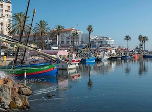 A marina with boats docked, palm trees, and buildings in the background. - St Cyprien, right on the water, beach or swimming pool (Saint-Cyprien)