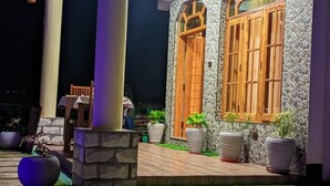 Ein Gebäude mit einer Stein-Fassade, Holztüren und Topfpflanzen.