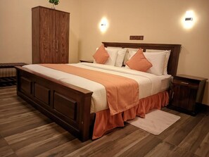 A bedroom with a wooden bed, a nightstand, a wardrobe, and two wall-mounted lights. - Green Birding Palace Ella (ella)